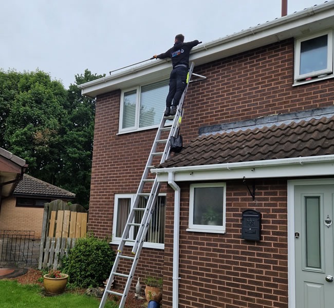 Clearing and unblocking guttering on a ladder